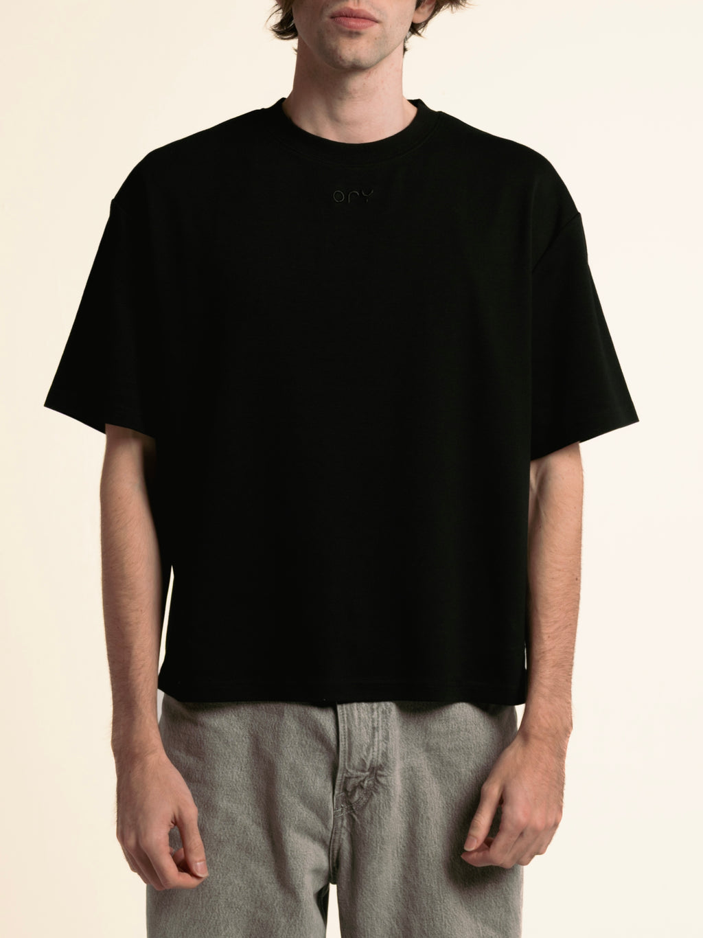 Man wearing the boxy black ORY Origin T-Shirt, front view