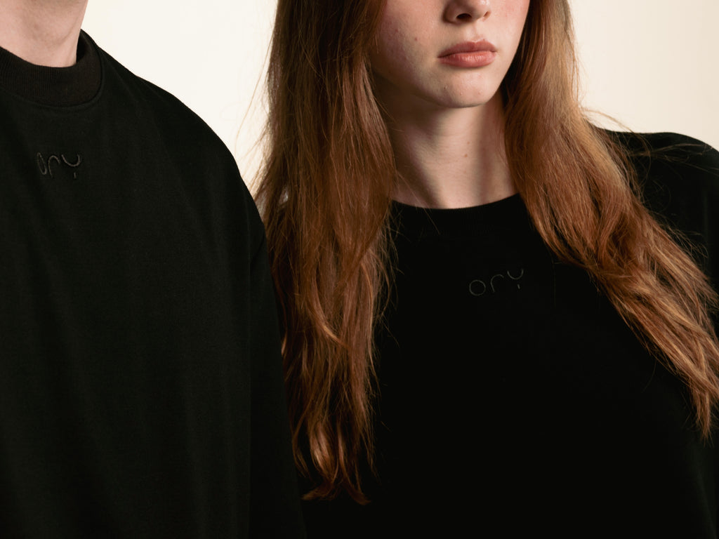 Close-up of the tonal ORY logo on the chest of the black Origin T-Shirt