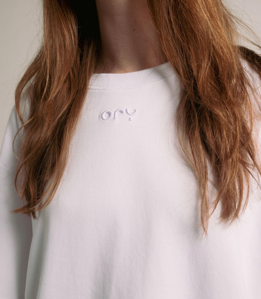 Close-up of the embossed ORY logo on the white Origin T-Shirt