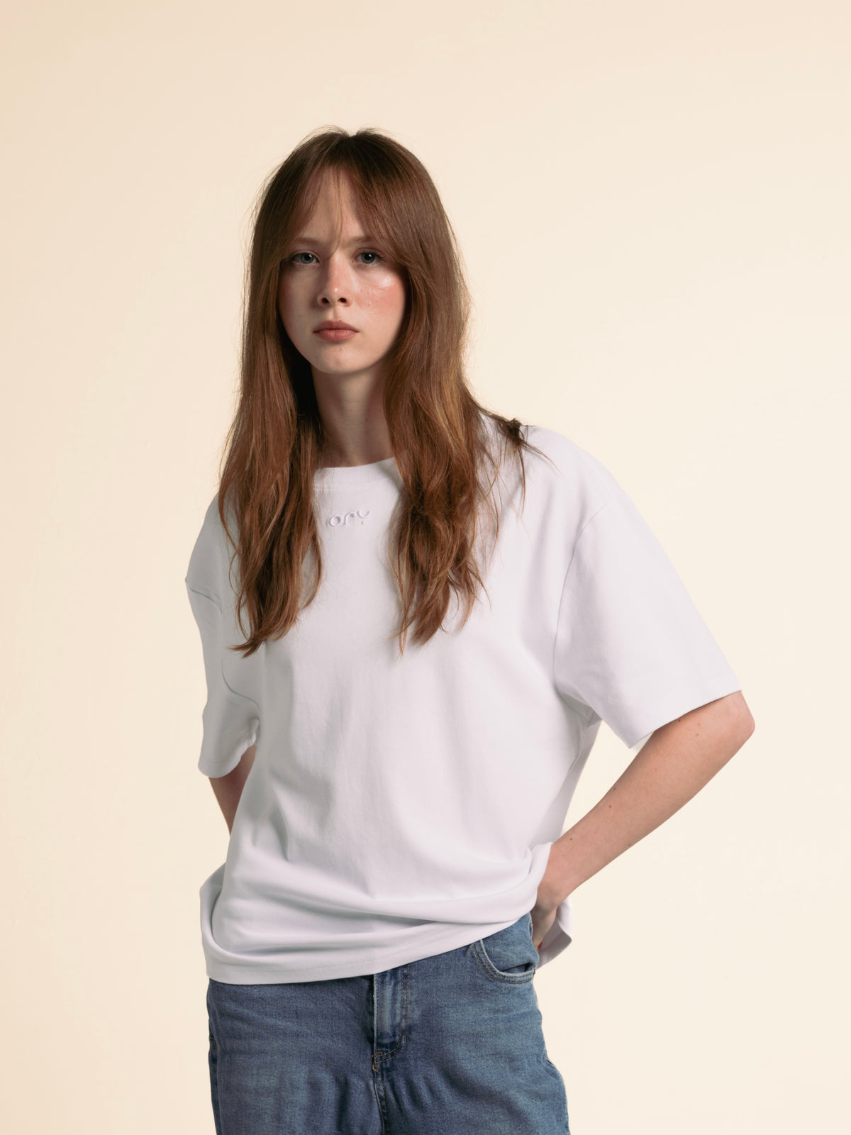 Woman wearing the boxy white ORY Origin T-Shirt, front view