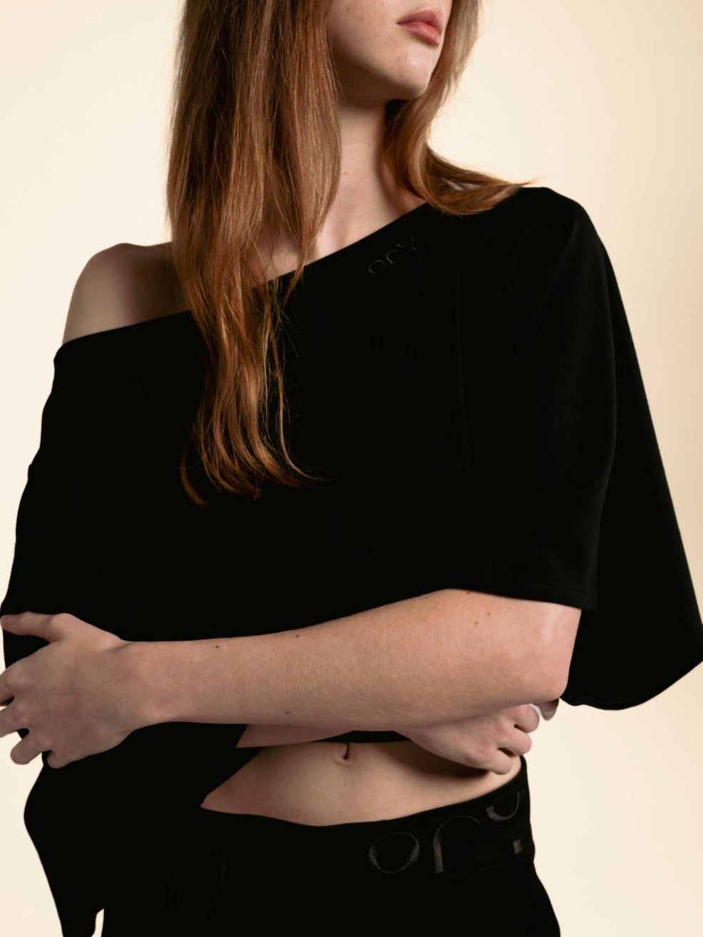 Woman wearing the black ORY Kimo Off-Shoulder Top with kimono-inspired sleeves