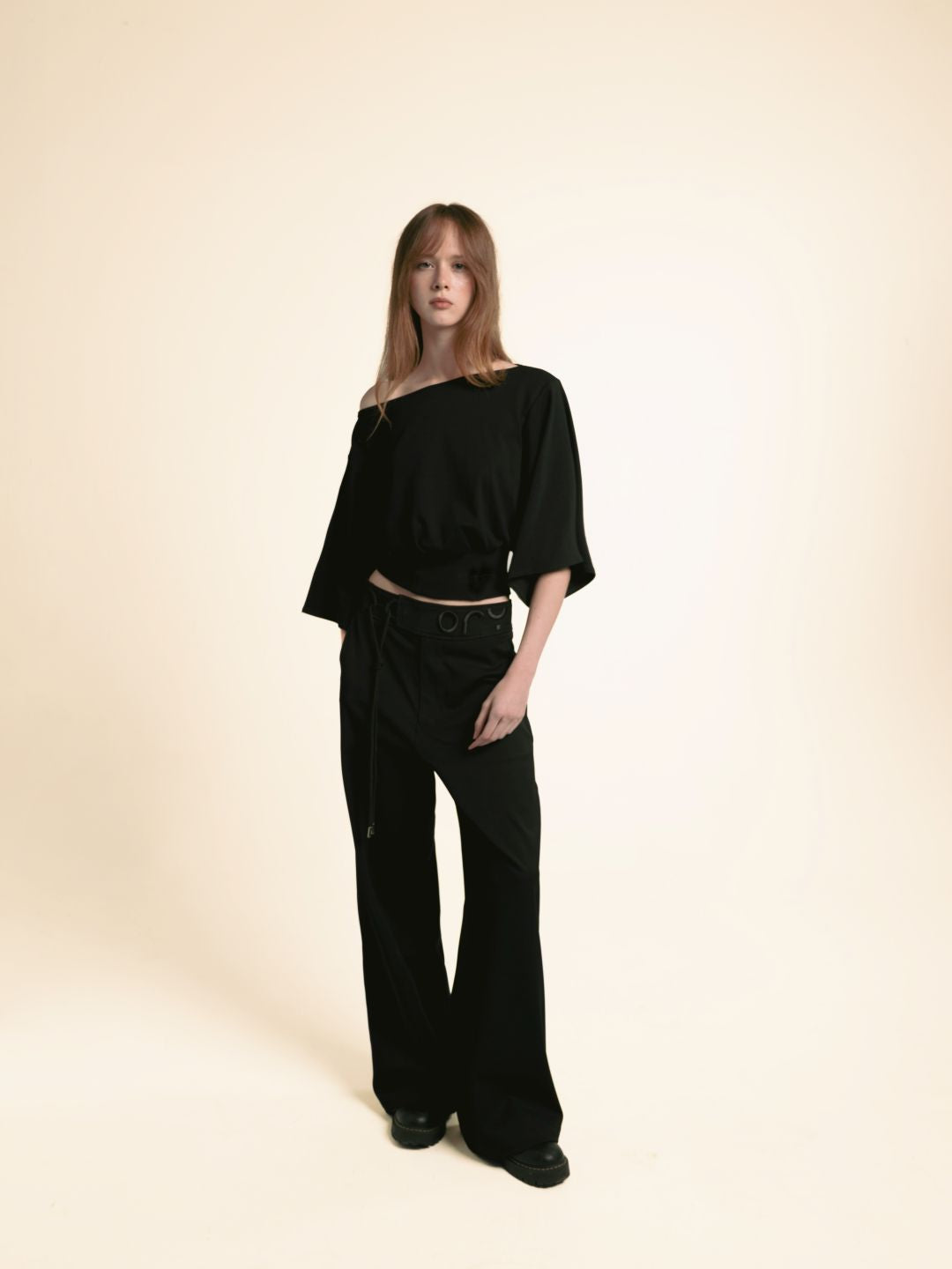 Woman wearing black ORY Origin wide-leg trousers with the Kimo Off-Shoulder Top